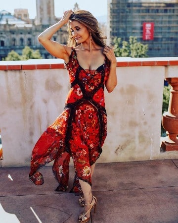 Picture of Anjali Bhimani in the red dress in a walking pose.